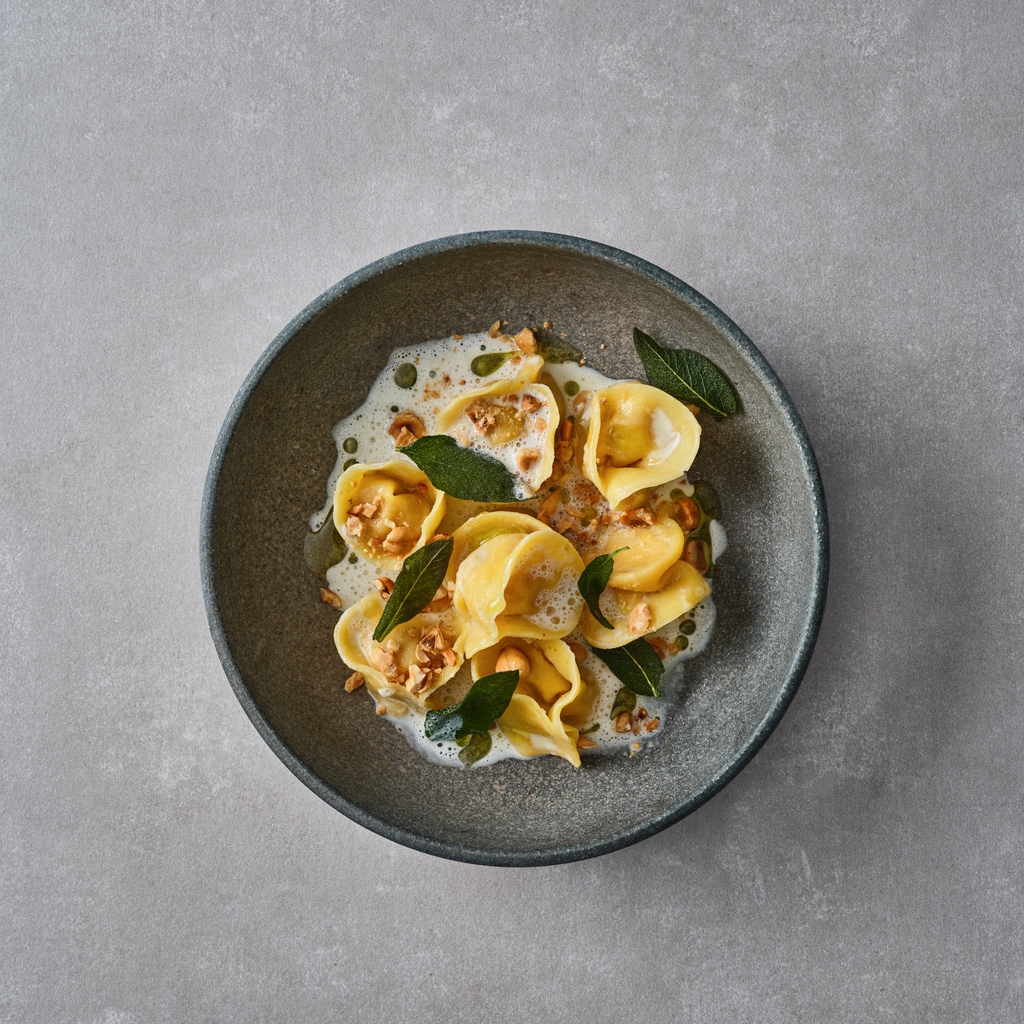 Kürbis-Ravioli mit Umami-Sahne und knusprigem Salbei